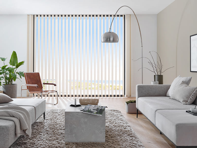 Helles, modernes Wohnzimmer mit bodentiefen Lamellen und direktem Blick auf den Strand